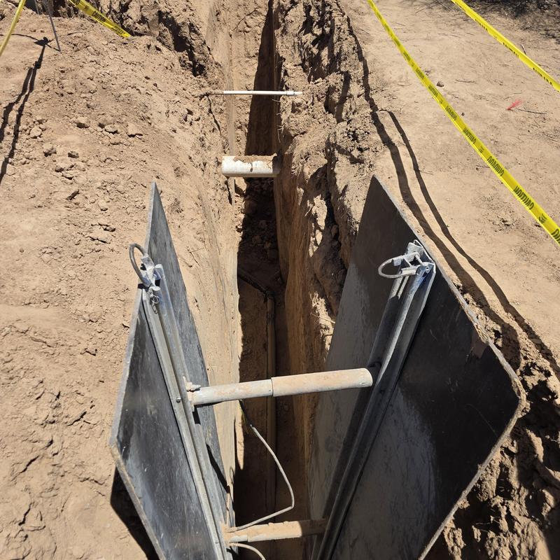 Sewer line trench with safety shoring panels