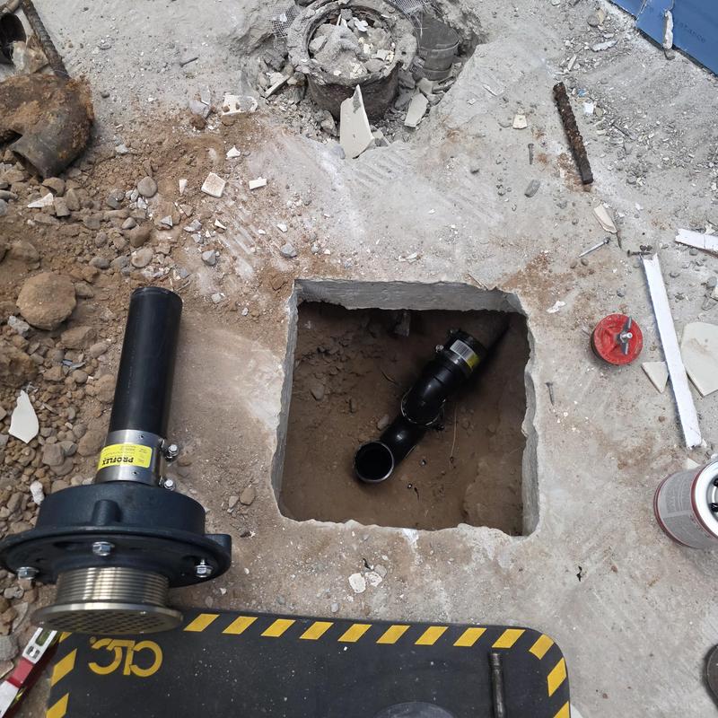 Floor drain with new ABS p-trap in concrete floor cutout