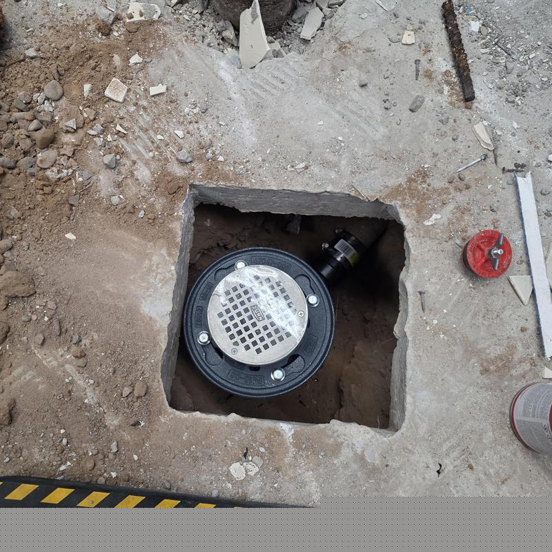 Floor drain with new ABS P-trap installed in concrete floor