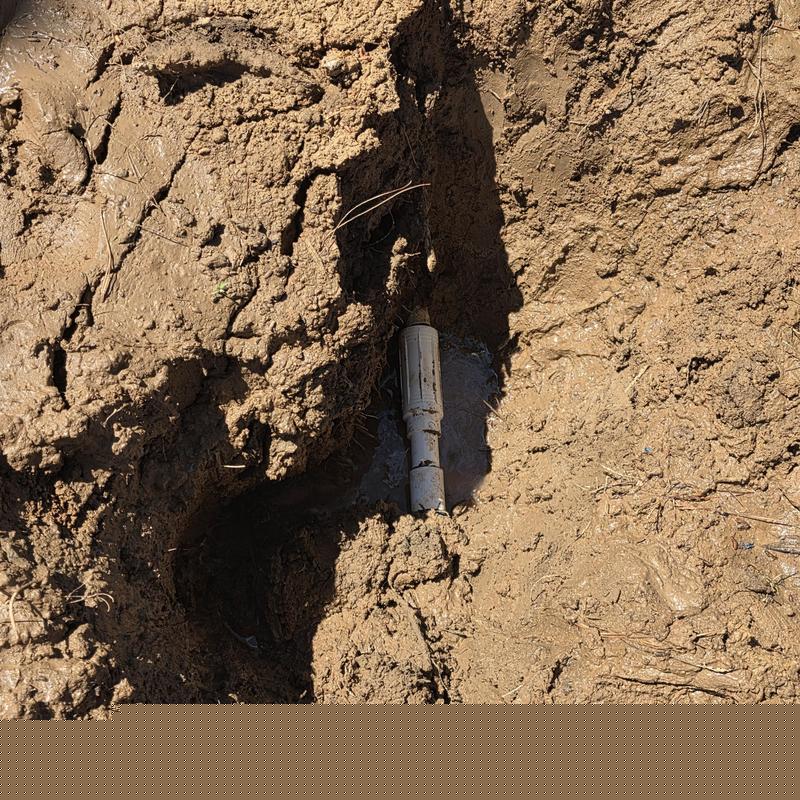 1-inch PVC water service line in mud trench