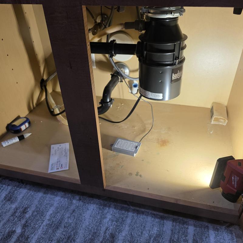 Garbage disposal unit under kitchen sink with tools