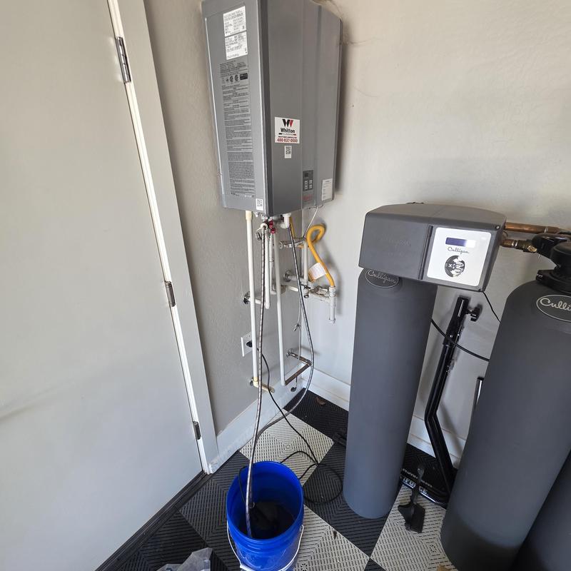 Tankless water heater flush setup with bucket and pipes