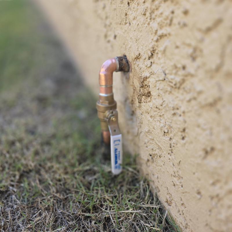 Ball valve on outdoor water service pipe near wall