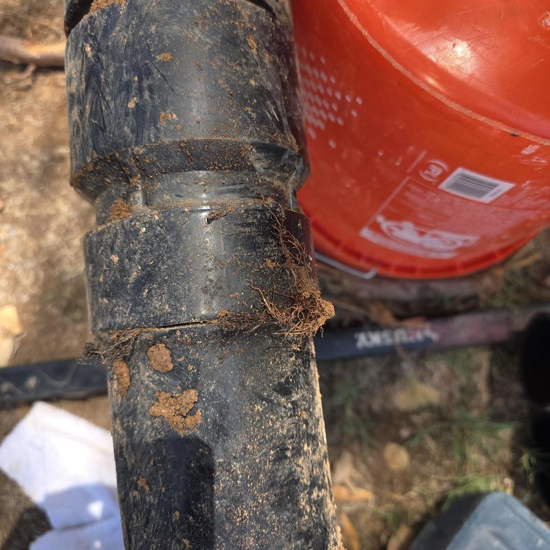 Broken ABS sewer main line with dirt and roots