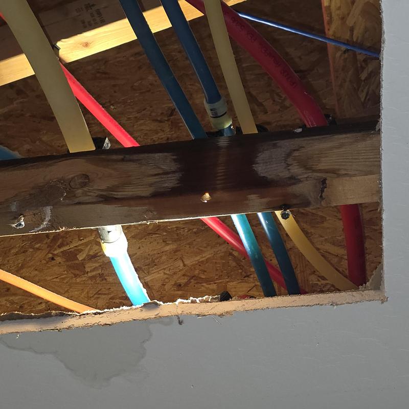 Pex water lines with leak stains in garage ceiling