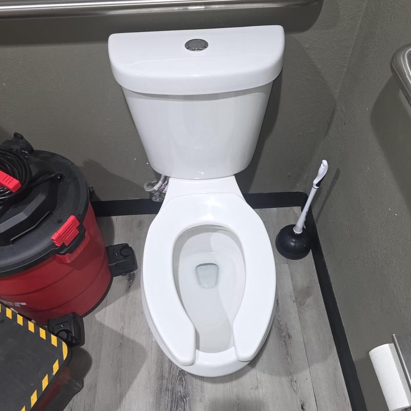 Commercial toilet with plunger and vacuum nearby