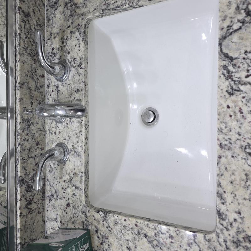 Lavatory sink with chrome faucet on granite countertop