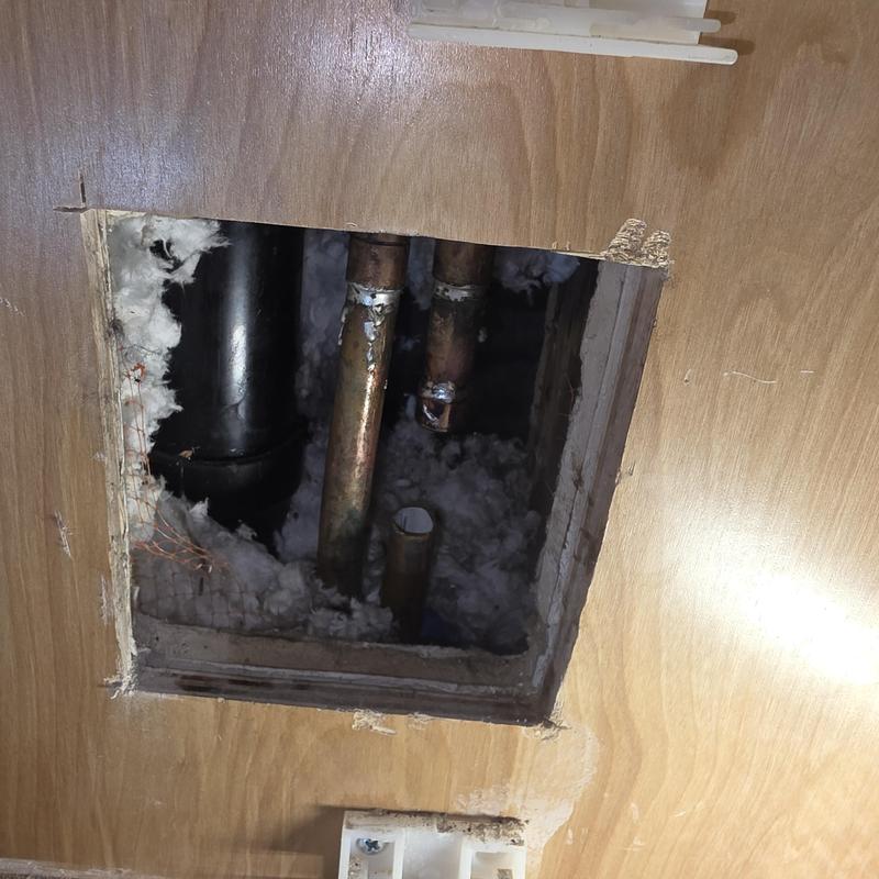 Copper cold water pipes inside wall access panel