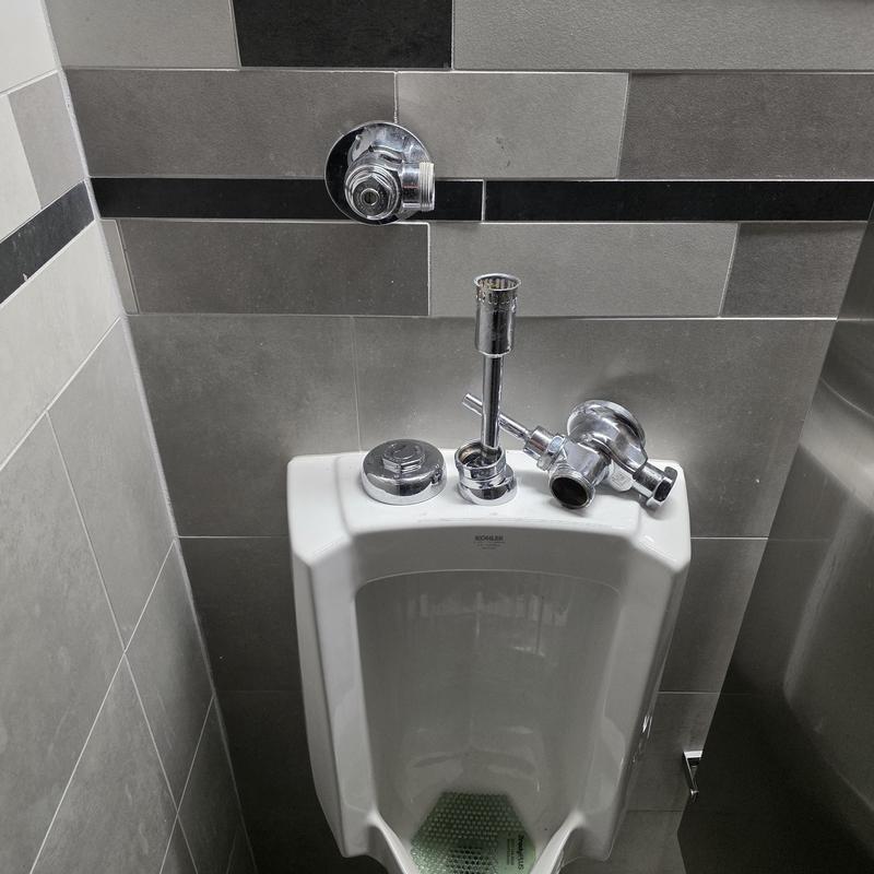Sloan flush valve and urinal installation in restroom
