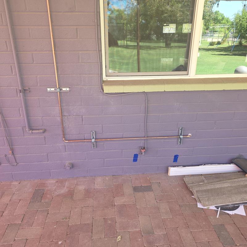 Copper hot water pipe rerouted on exterior wall