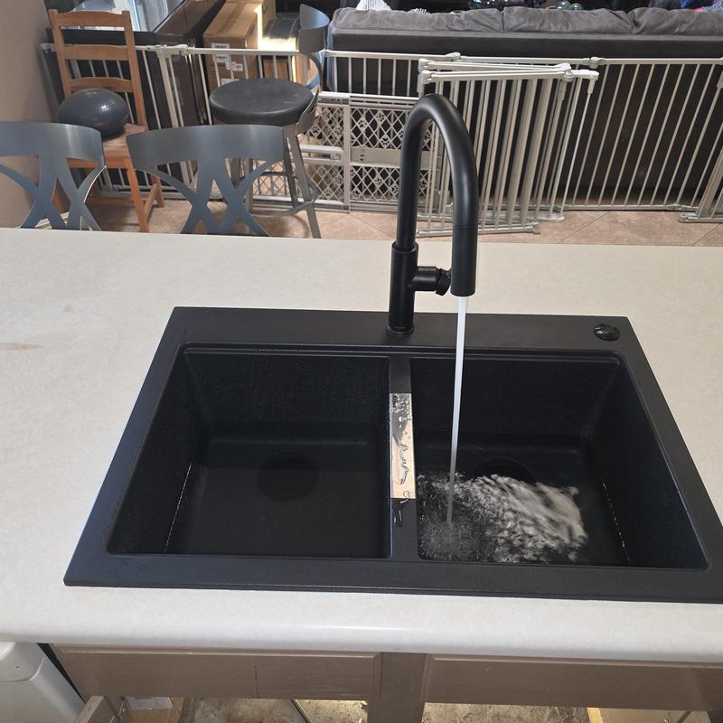 Kitchen sink with black faucet running water